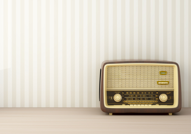 Image of an dark brown old radio in front of a striped wall 