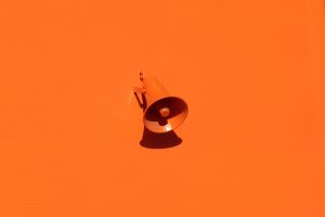 Orange megaphone attached to an orange wall
