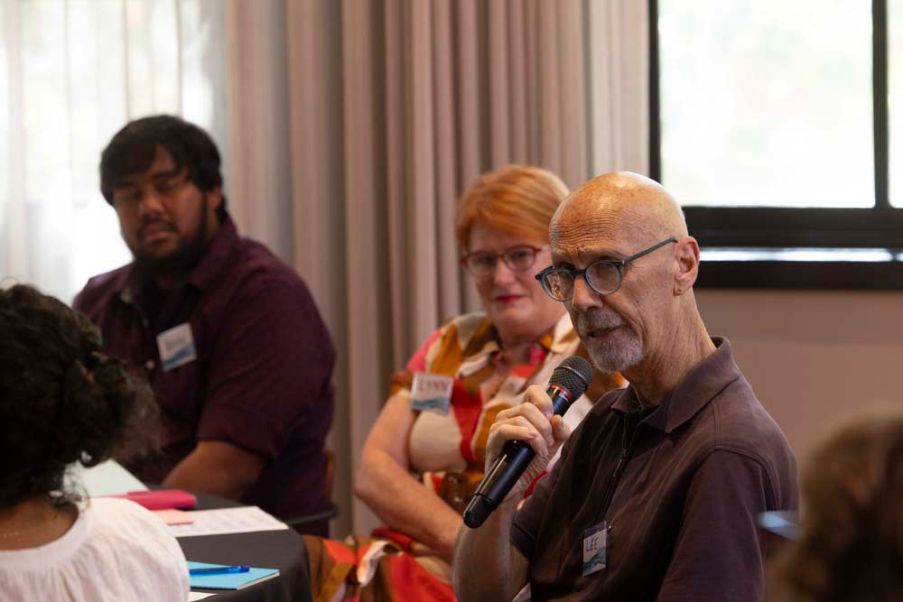 Lee Eeles makes a comment using a hand-held microphone